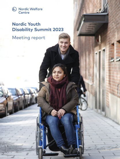 Two young people outsdoors, one is sitting in a wheelchair.