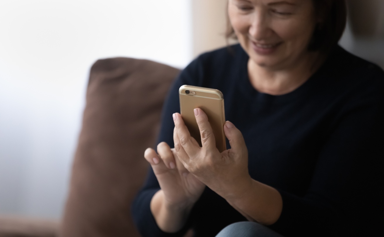 Woman in her 60s using telehealth app on her mobile phone