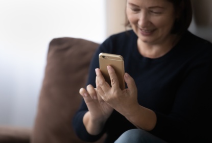 Woman in her 60s using telehealth app on her mobile phone