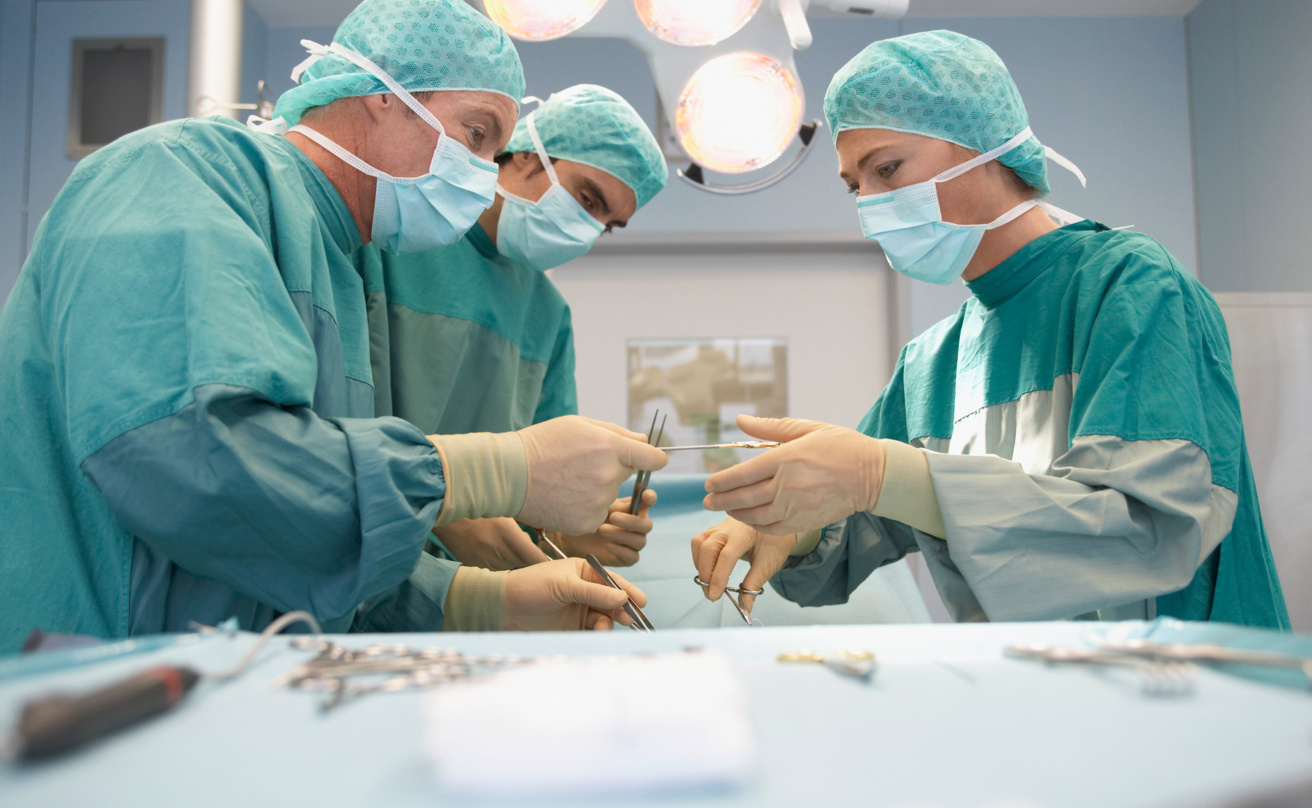Three surgeons at work in operating theatre