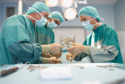 Three surgeons at work in operating theatre