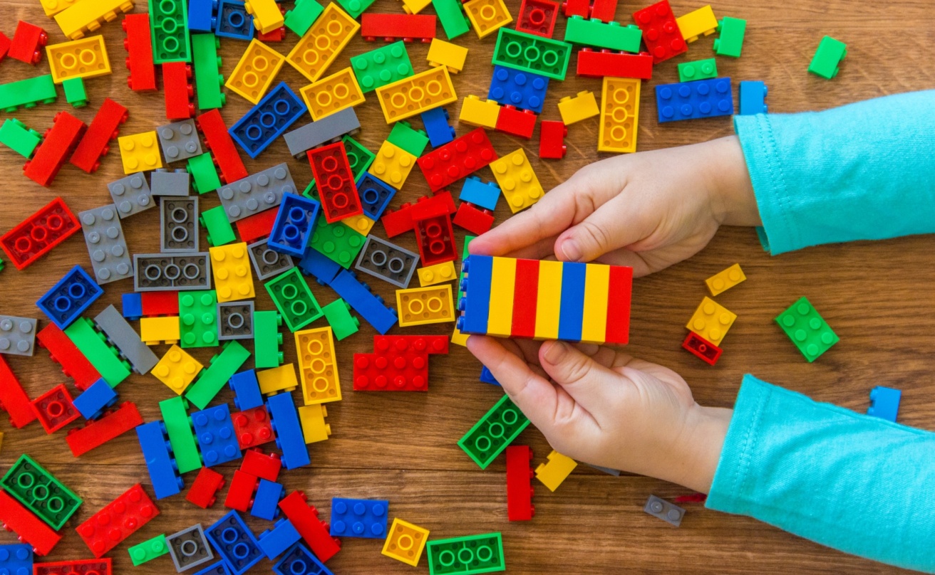 childrens hands playing with colourful lego