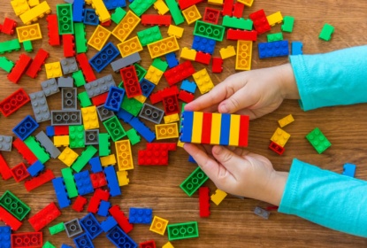 childrens hands playing with colourful lego