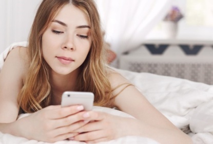 Safer Digital Democracy. Girl in bed with cellphone