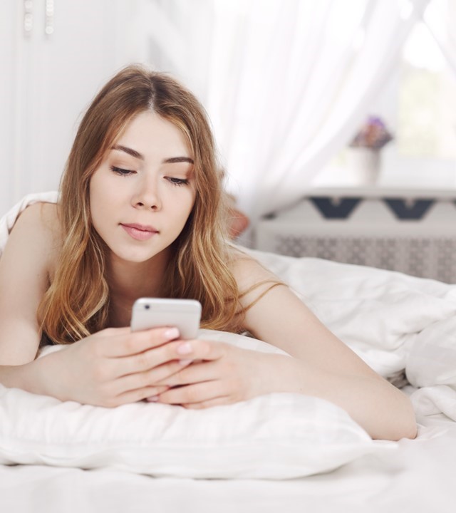 Safer Digital Democracy. Girl in bed with cellphone