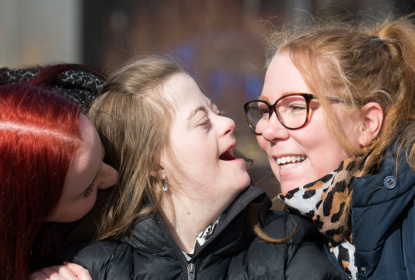Tre kvinnor har huvudena tätt och skrattar ihop för att visa kommunikativa relationer