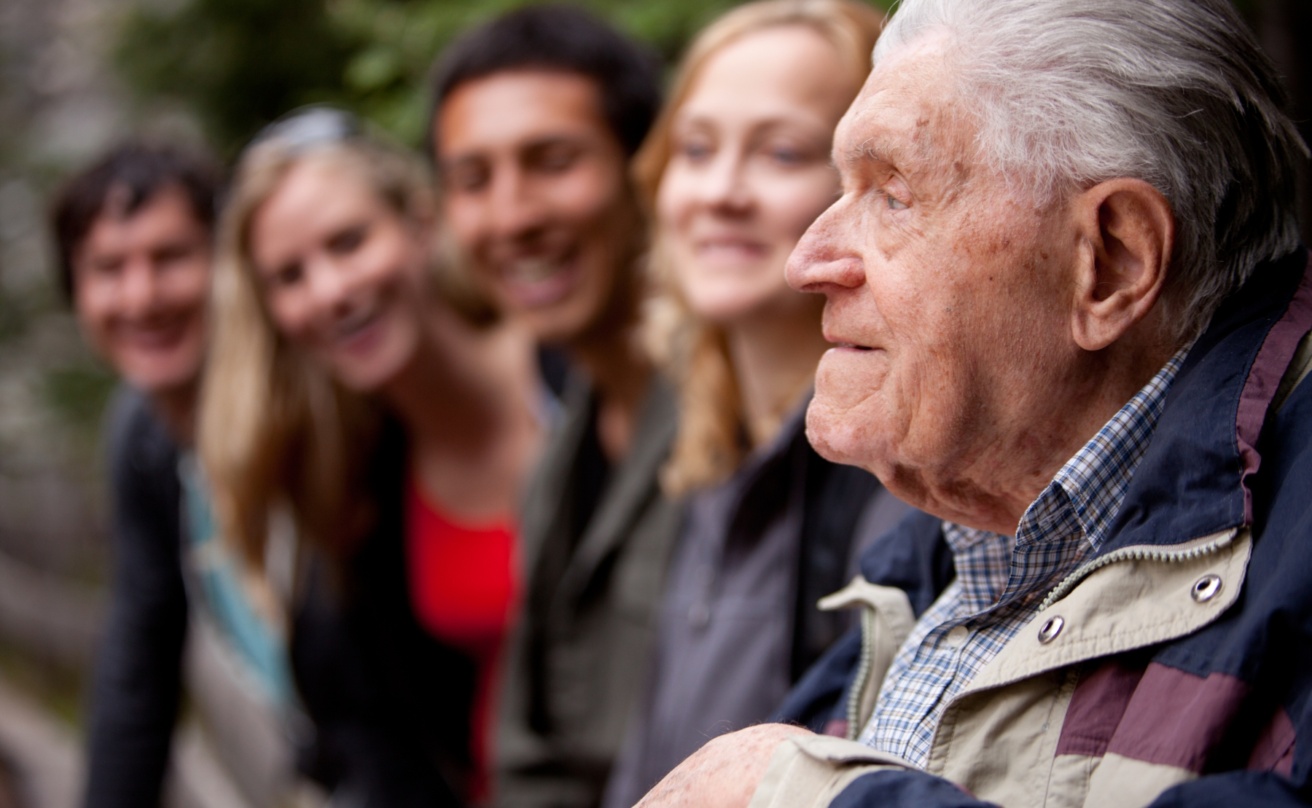 Older man with younger people in the background