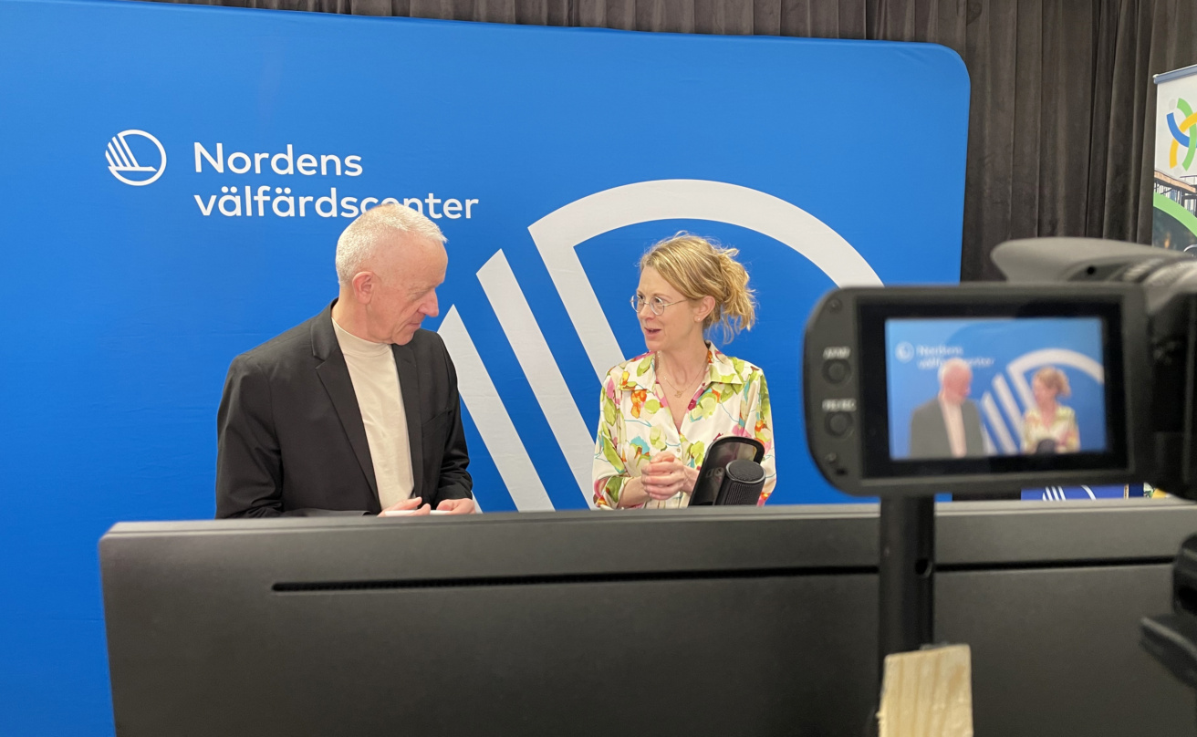 Ola Linder och Guri H Gabrielsson står i studion framför en blå bakgrund