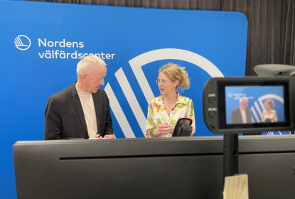 Ola Linder och Guri H Gabrielsson står i studion framför en blå bakgrund