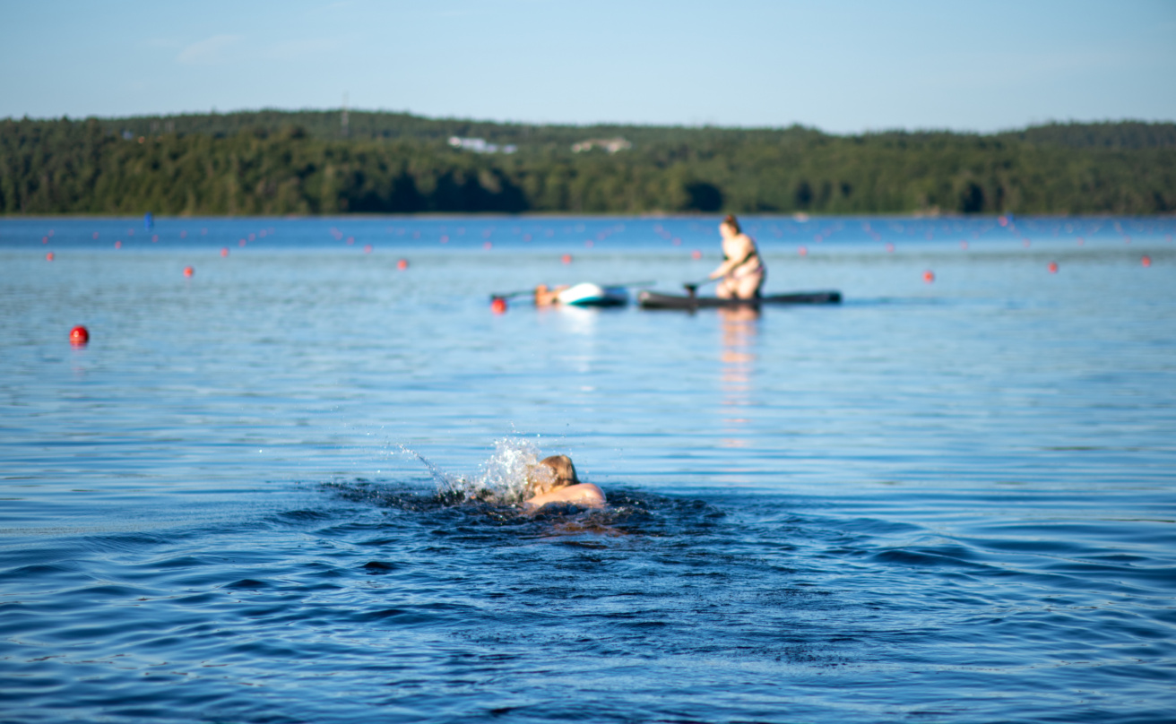 Child swimming in a lake in rural Scandinavia on a sunny summer day