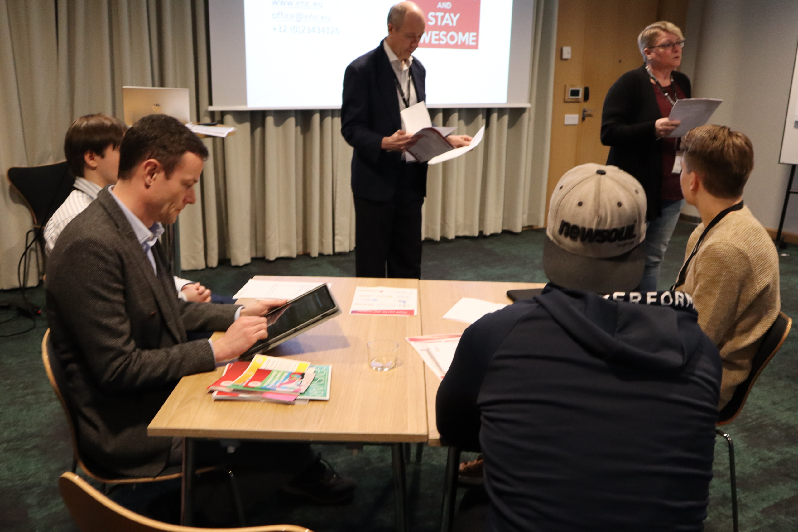 Participants in a meeting that has recieved funding from the Nordic Welfare Centre, listening to a speaker in a conference room