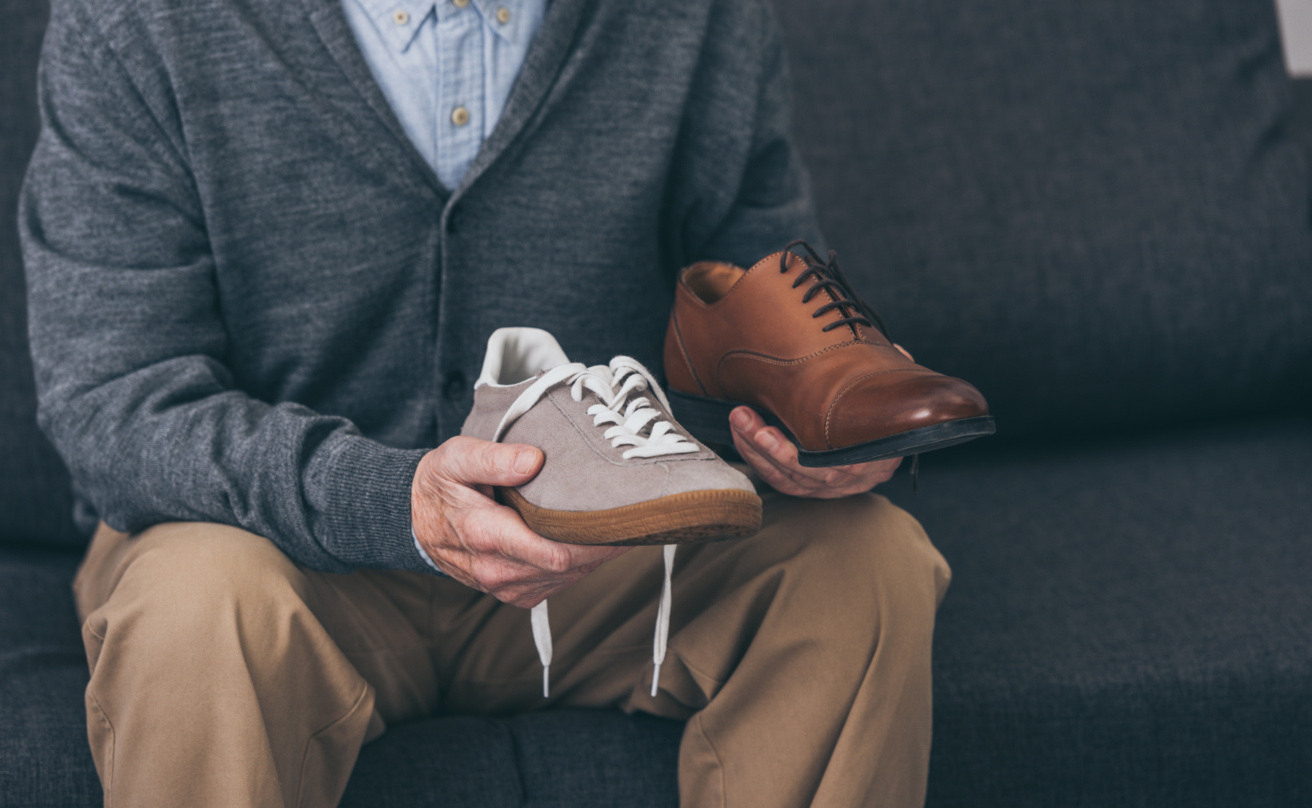 Senior man holding classic and modern shoe