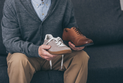 Senior man holding classic and modern shoe