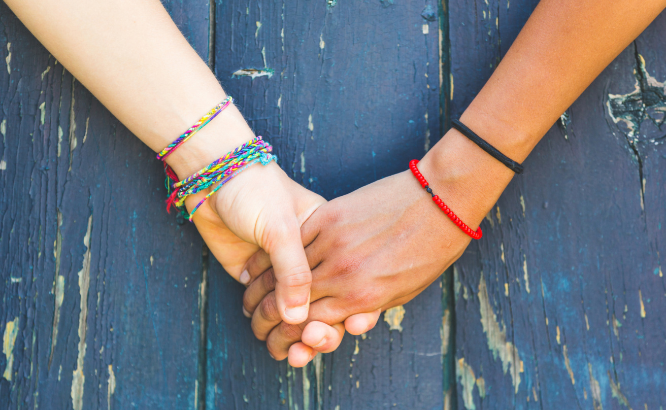 friends holding hands blue backgrund