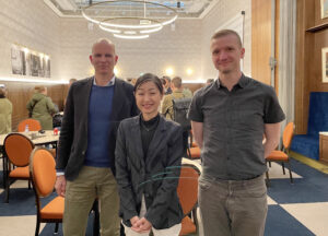 Patrick Kermit, Hisayo Katsui och Stefan Hardonk på en gruppbild i ett mötesrum. De ler mot kameran.