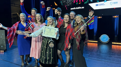 En grupp ungdomar på scen tar emot diplom.