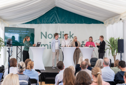 Paneldiskussion på scen i Nordens Telt, moderator och fem deltagare.