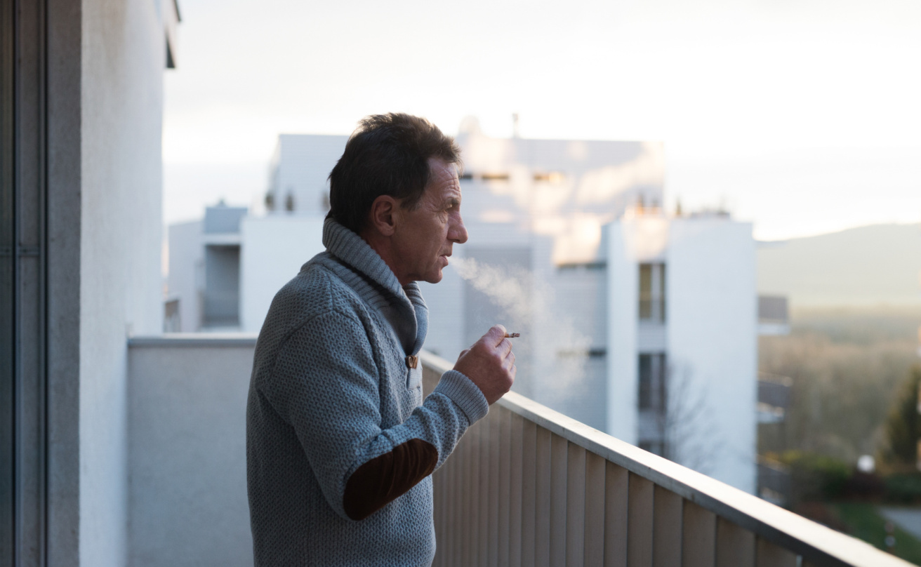 Senior man smoking on balcony