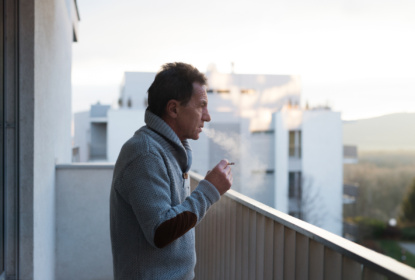 Senior man smoking on balcony
