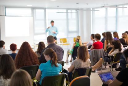 man speaking in fron of audience at event