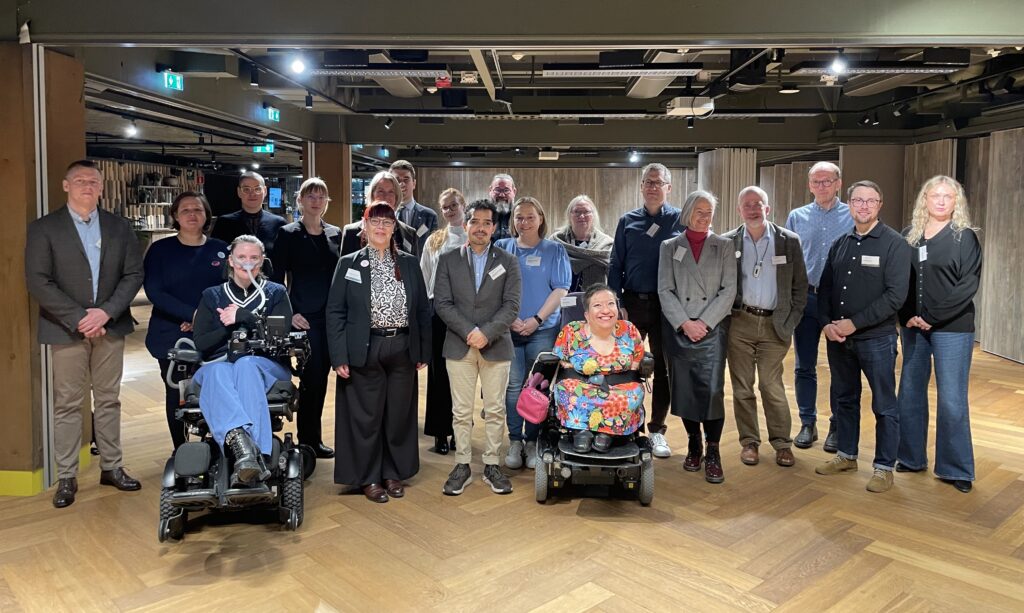 Gruppbild med 20 människor som står i ett öppet utrymme, klädda i kontorskläder