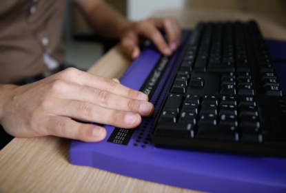 Blind person using computer with braille keyboard