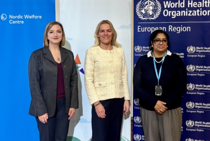 Three people stand side by side in front of banners for the Nordic Welfare Centre and the World Health Organization, posing for a formal photo.