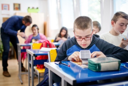 pojke i klassrum jobbar med anpassat lärmaterial