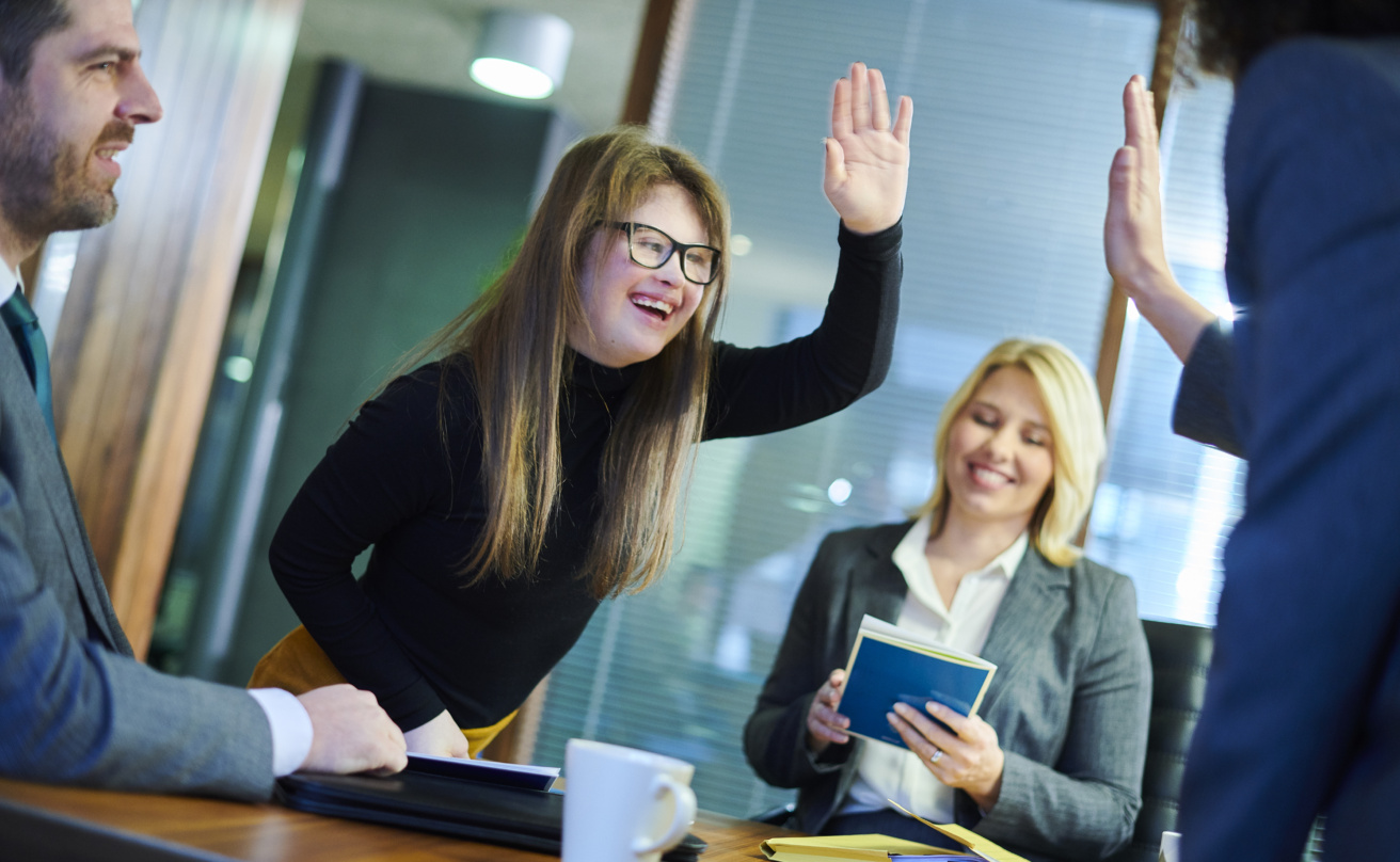 Girl in meeting giving a high five and smiling