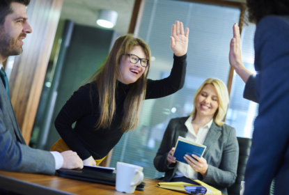Girl in meeting giving a high five and smiling
