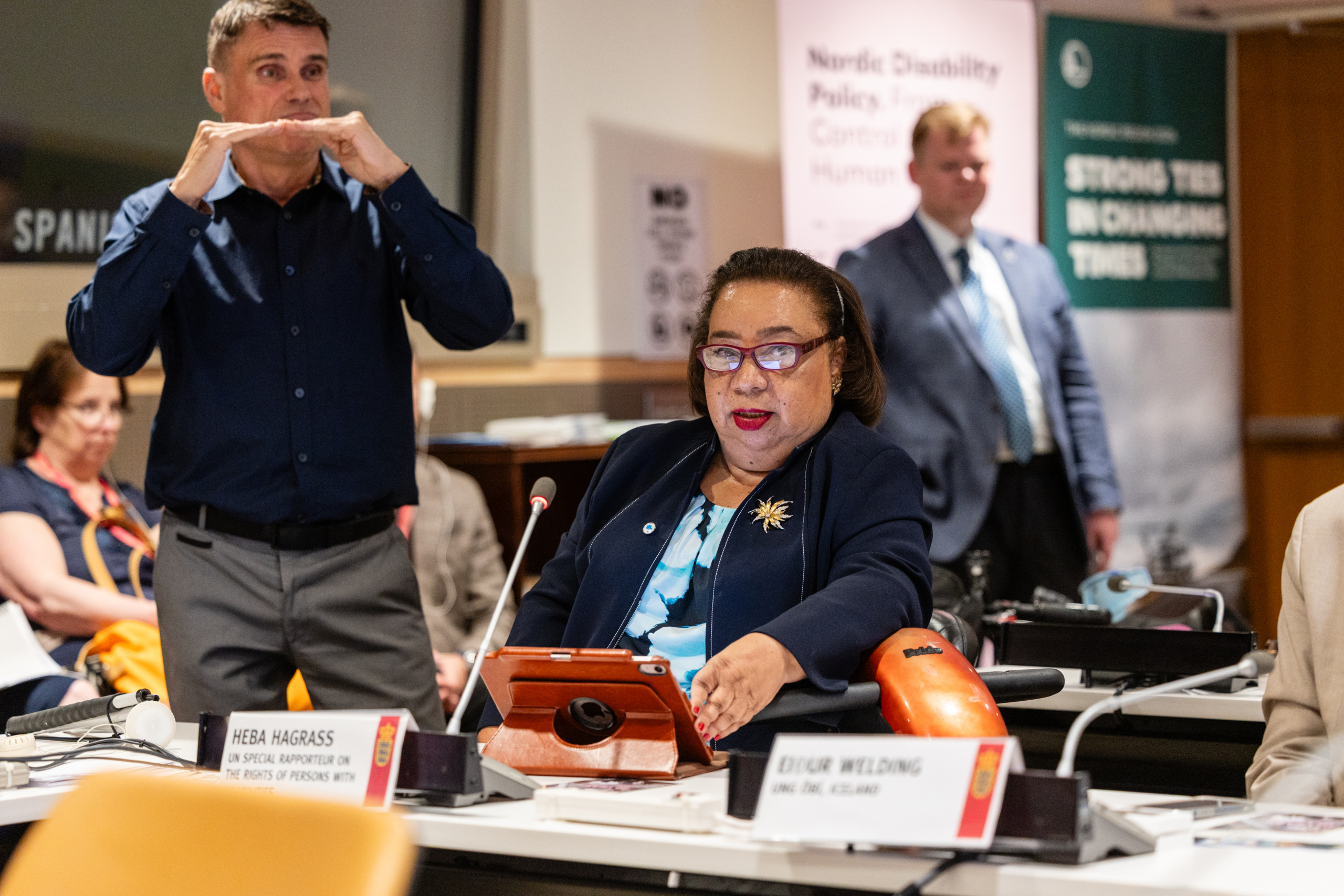 Heba Hagrass speaking, sitting at a conference table