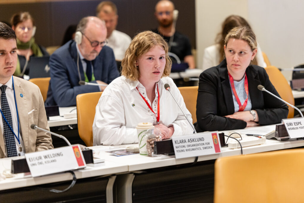 Eiður Welding, Klara Asklund and Siri Espe sitting at a conference table, Asklund in the middle speaking