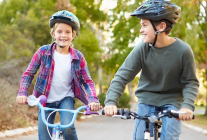 Två glada barn cyklar