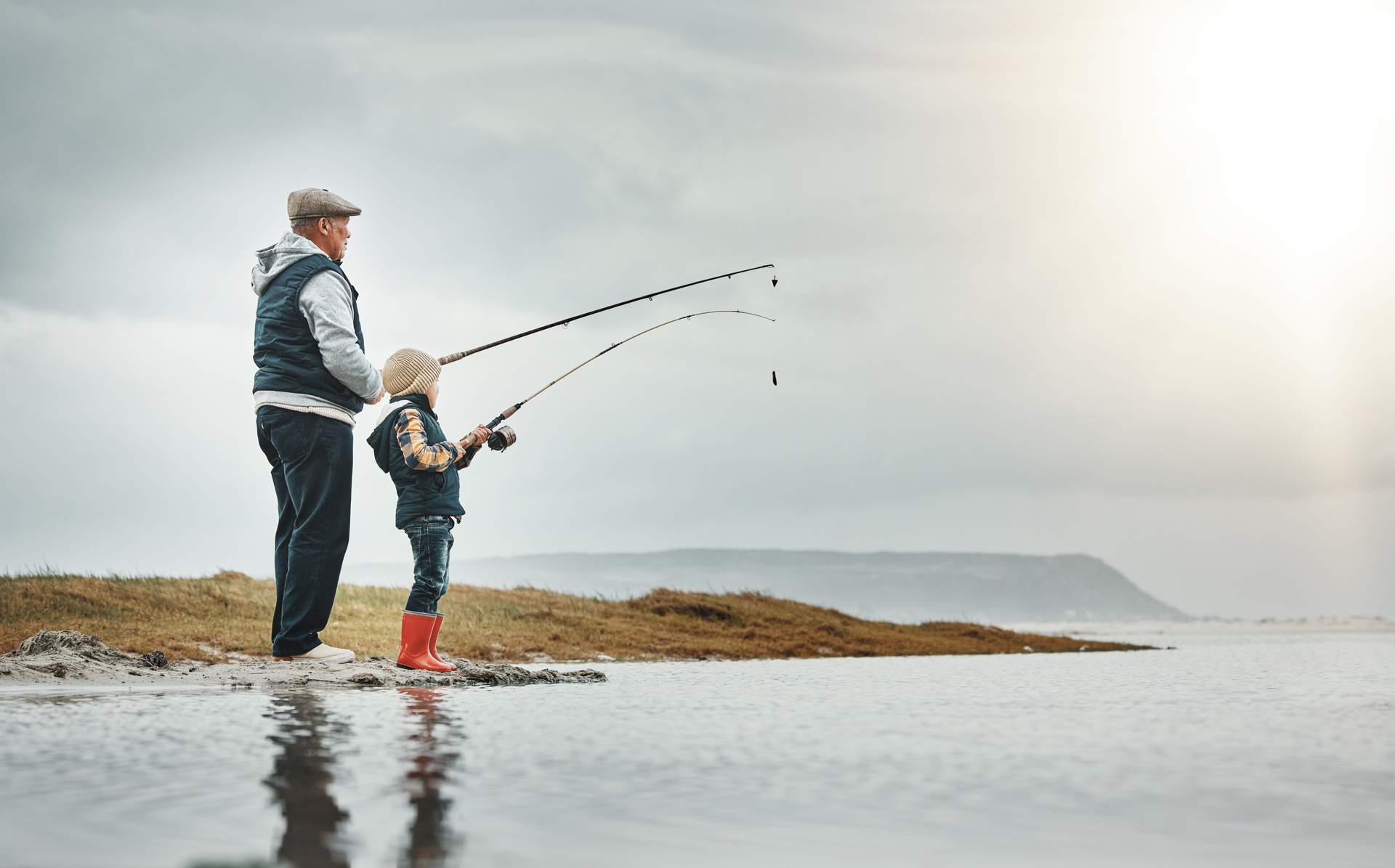 Äldre man och ett barn fiskar tillsammans