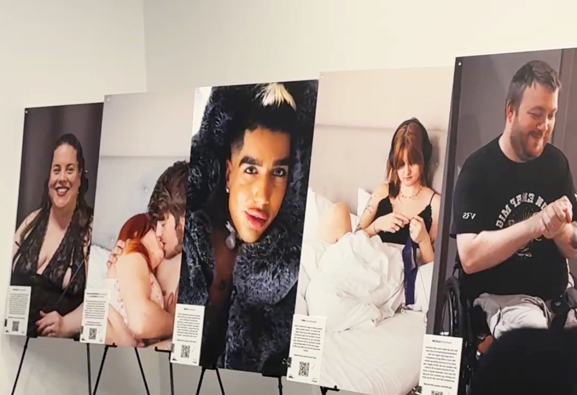 Five large portrait photographs of people with deafblindness in different everyday situations, displayed on black easels at an exhibition. Each photograph is accompanied by an information card with text and a QR code.