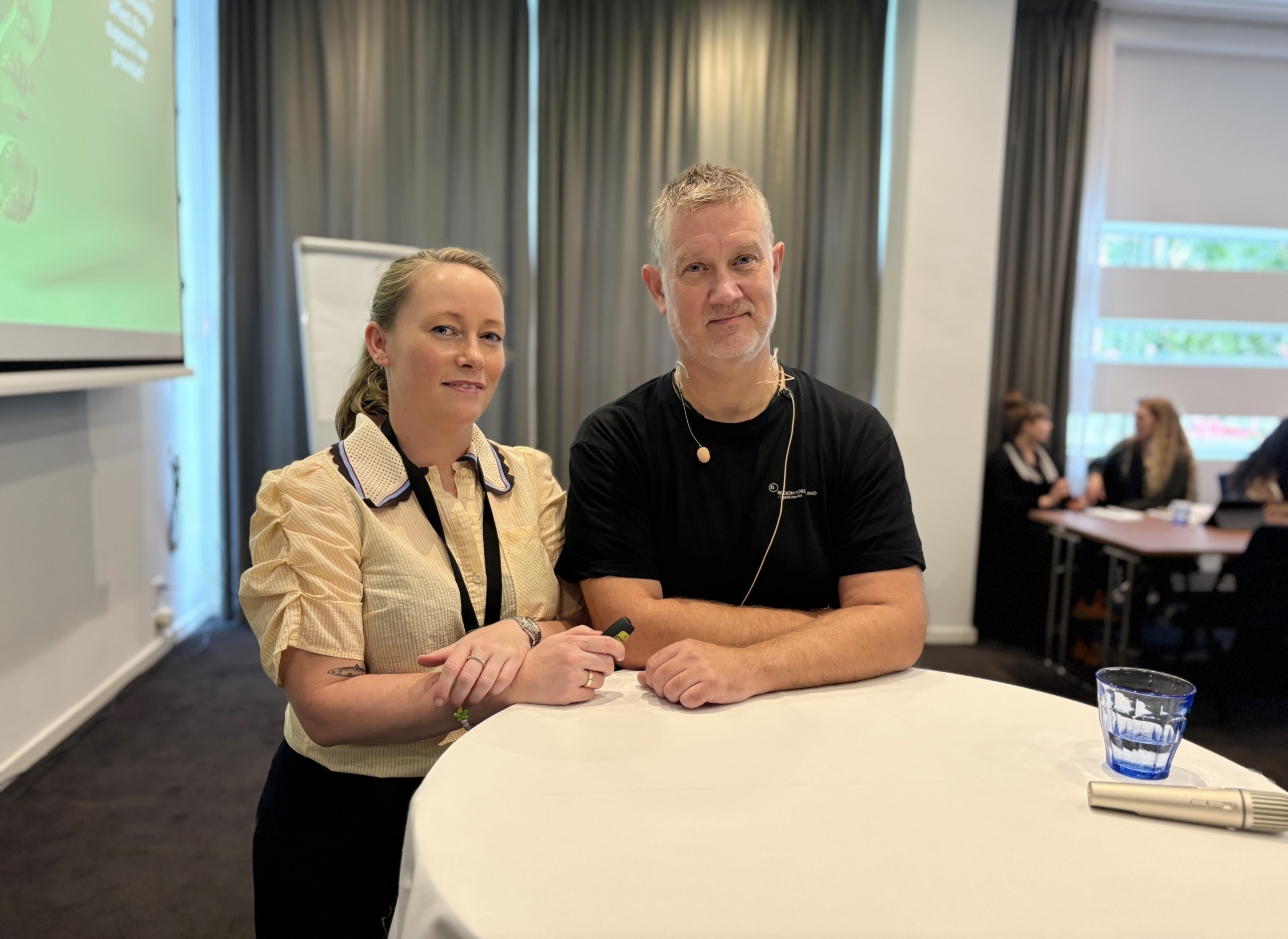 Portrait of a woman and a man in a conference room